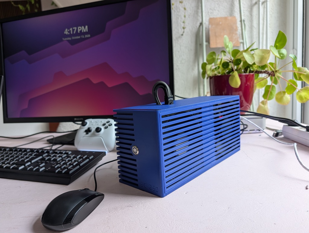 Side view of the blue 3D-printed BC-250 enclosure showing the dual 140mm intake fans behind the slatted side vents